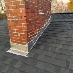 Chimney flashing with lead installed on asphalt shingle roof in Seacoast NH